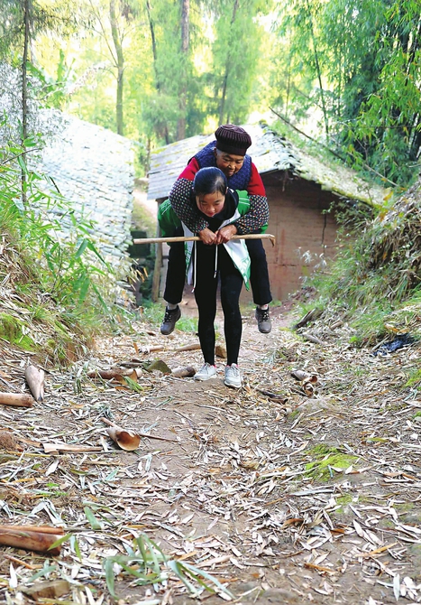 一名瘦高身形,面容清隽的女孩正背着一位老人